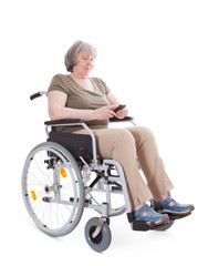 Fototapeta na wymiar Senior sitting in wheelchair using smart phone