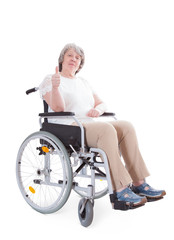 Obraz premium Senior sitting in wheelchair showing thumbs up