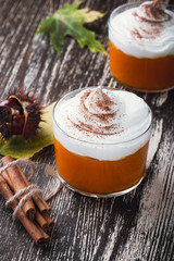 Homemade autumn dessert of pumpkin mousse with whipped cream