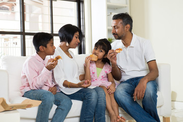 happy indian family eating pizza at home