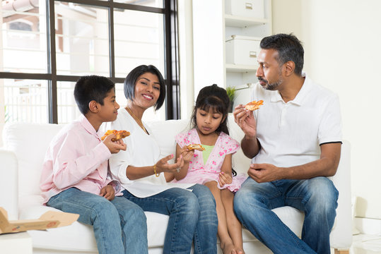 Happy Indian Family Eating Pizza At Home