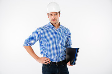 Handsome young man building engineer in helmet with folder