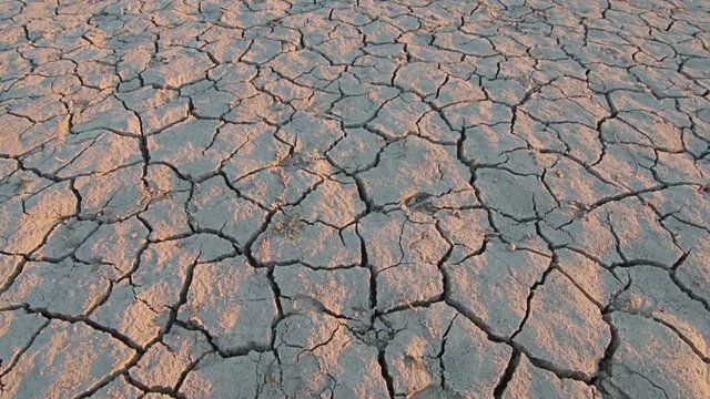 Sunset above drought disaster, dry soil. Climate change, global warming