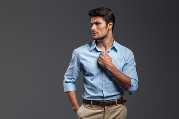 Portrait of a casualman buttoning his shirt isolated