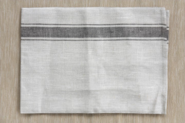 top view blank gray plate mat (napery) or dish towel on brown ta