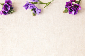 Purple blue flowers on linen toning copy space background