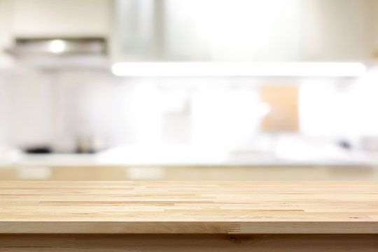Wood countertop (or kitchen island) on blur kitchen interior background