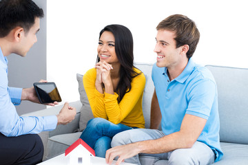 Young couple meeting with real estate agent at home