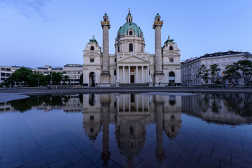 Fototapeta na wymiar Karlskirche in Vienna Austria at sunset with reflection and purple sky, St Charles's church
