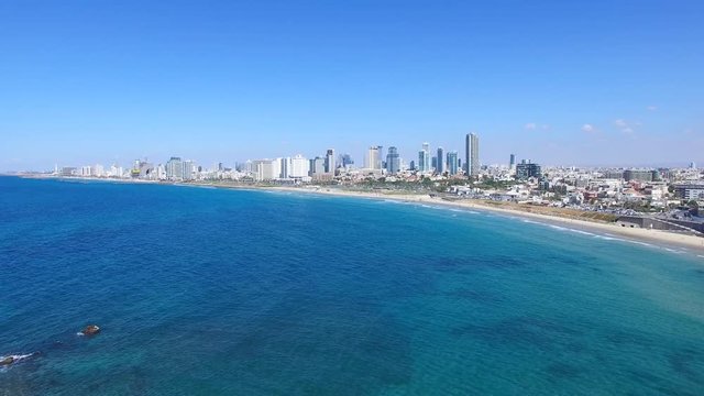 Tel Aviv's modern skyline with Jaffa's ancient port and old city - Aerial footage