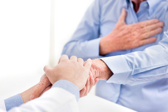 Doctor holding senior male patient hand