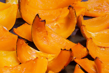 Slices of roasted pumpkin with honey on background  the oven pan