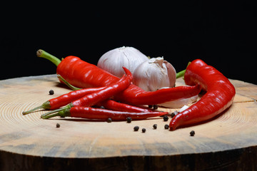 Red chilli papper, garlic on wood texture background