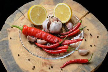 Red chilli papper, garlic and lemon on wood texture background