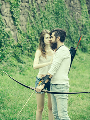 Young attractive couple shoots from the bow