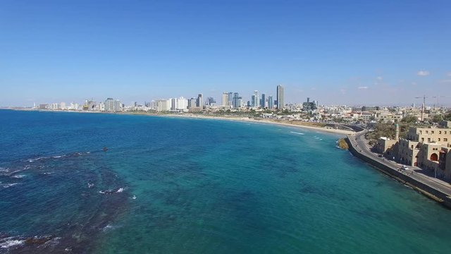 Tel Aviv's modern skyline with Jaffa's ancient port and old city - Aerial footage