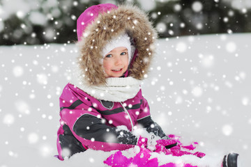 Fototapeta na wymiar happy kid in winter clothes playing with snow