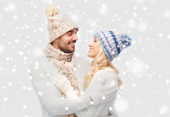 smiling couple in winter clothes hugging