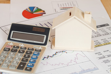 Miniature house with money and chart