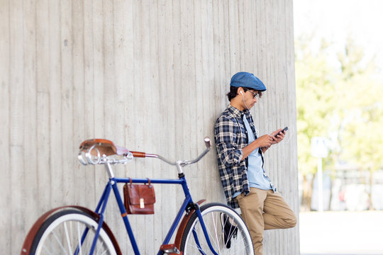 man with smartphone, earphones and bicycle