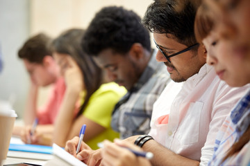 group of international students writing at lecture