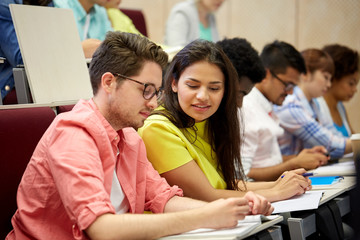 group of international students writing at lecture