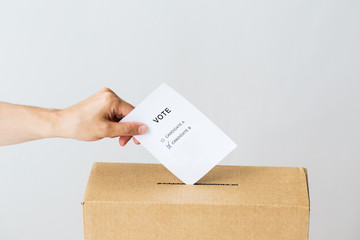man putting his vote into ballot box on election