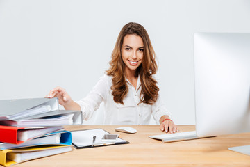 Smiling cheerful businesswoman sitting at her working place