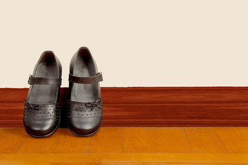 School Girl Black Pair of Shoes on Wooden Floor © arapix