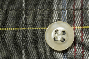 button fastened to the colorful tartan shirt