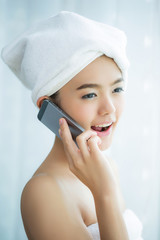 Asian beautiful women dressed in towel Her mobile telephone.
