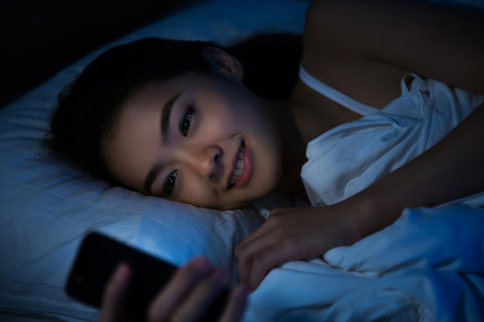 Asian Women Are Using The Smart Phone On The Bed Before She Slee