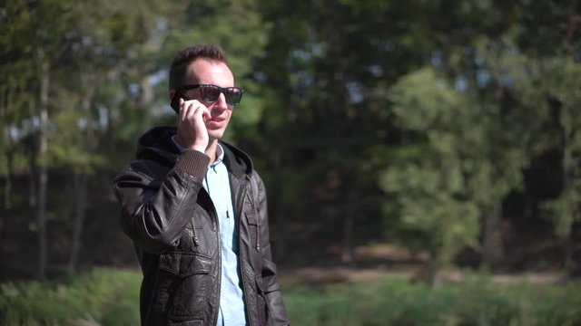 Young man in sunglasses talkning by phone