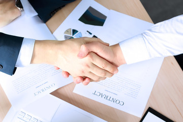 Close-up image of a firm handshake between two colleagues after