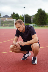 Obraz premium mann macht eine pause beim sport und schaut auf sein mobiltelefon