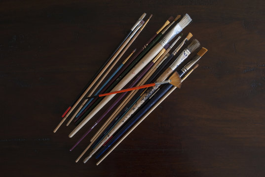 collection of all sorts of paintbrushes for oil and acrylic painting on wooden background