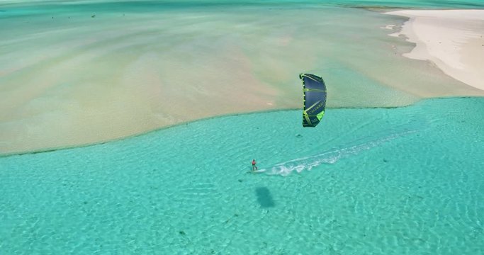 Aerial view young man kitesurfing in tropical blue ocean, extreme sport
