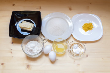 Ingredients for lemon muffins on a wooden surface