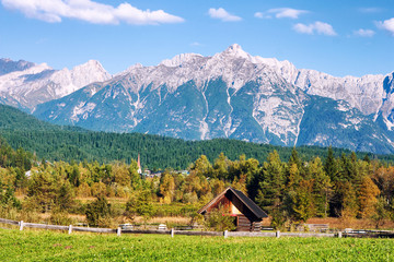 Idyllic tyrolean (Austria, Europe) landscape with hills, forest, farm house, blue sky and green...