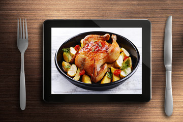 Table appointments and tablet. Photo of food on tablet screen.