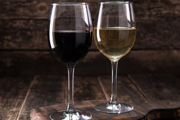 white and red glasses of wine on vintage wooden table