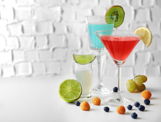 Delicious cocktails with berries on white table