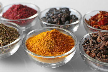 Various spices in glass bowls, close up