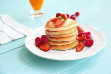 Tasty pancakes with berries on plate