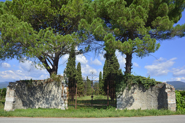 An old historic stone gate, and what remains of the wall, in rural north east Italy
