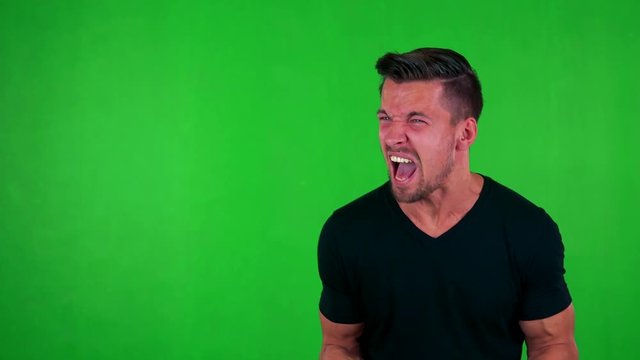 young handsome caucasian man is angry - green screen - studio
