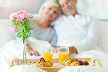 Senior couple enjoying breakfast in bed
