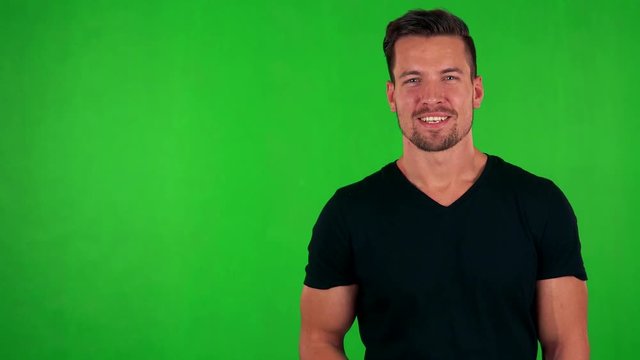 young handsome caucasian man talks to camera - green screen - studio