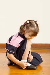 Little School Girl Tying her Black Shoes