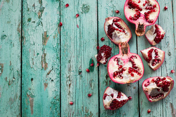 Fresh pomegranates in an old box with leaves. On wooden background.